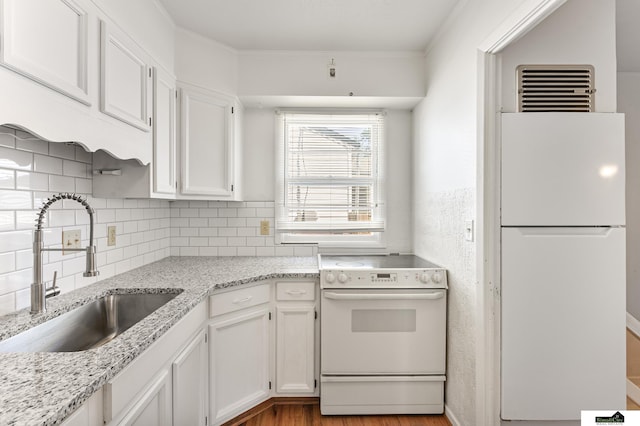 1500 Burnham St, Lincoln, NE 68502 - kitchen featuring white appliances, a sink, white cabinets, decorative backsplash, and light stone countertops