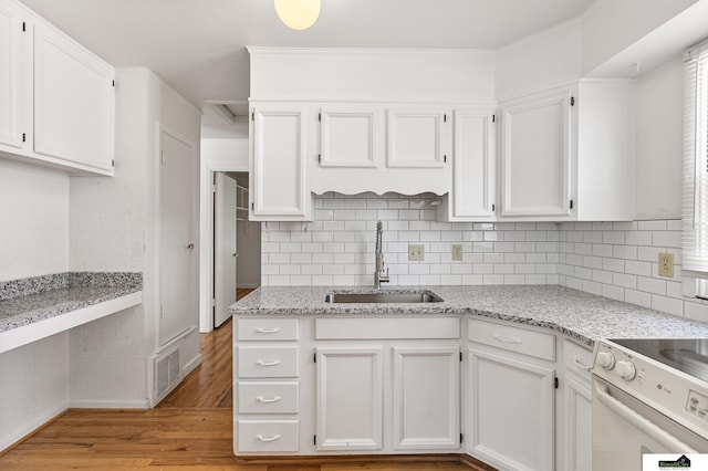 1500 Burnham St, Lincoln, NE 68502 - kitchen featuring a sink, white cabinetry, baseboards, light wood-style floors, and tasteful backsplash