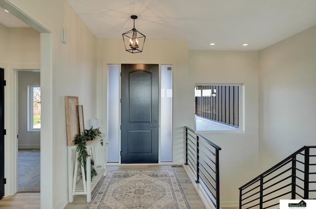 foyer entrance with an inviting chandelier, wood finished floors, recessed lighting, and baseboards