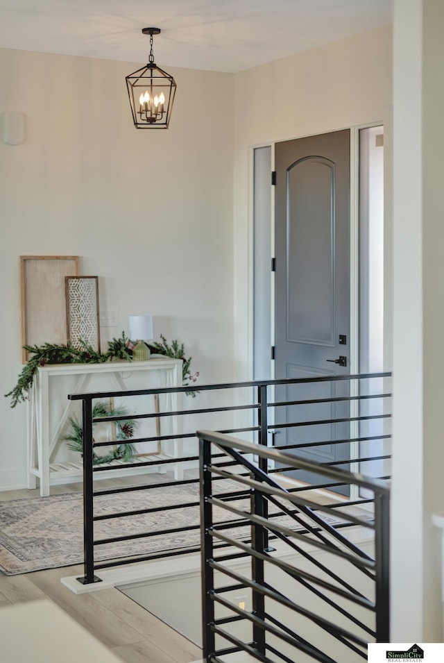 interior space with a chandelier, wood finished floors, and an upstairs landing