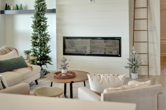 living room with wood finished floors and a glass covered fireplace