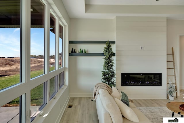 living room with visible vents, light wood-type flooring, and baseboards