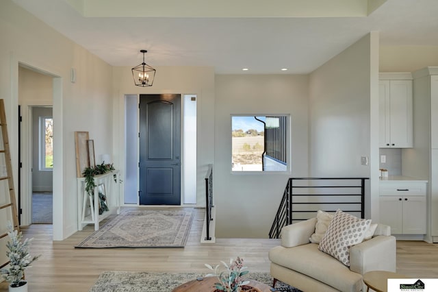 foyer entrance with a chandelier, recessed lighting, and light wood finished floors