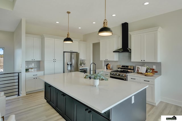 kitchen featuring recessed lighting, decorative backsplash, light wood-type flooring, wall chimney range hood, and appliances with stainless steel finishes