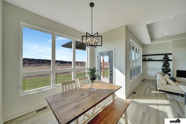 dining area featuring an inviting chandelier, visible vents, light wood-style flooring, and baseboards