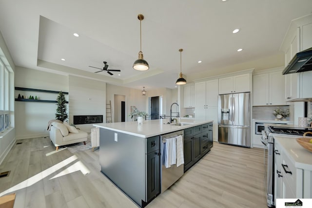 kitchen with white cabinetry, appliances with stainless steel finishes, light countertops, and a sink