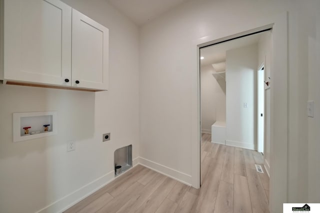 clothes washing area featuring light wood-style flooring, cabinet space, hookup for an electric dryer, and washer hookup