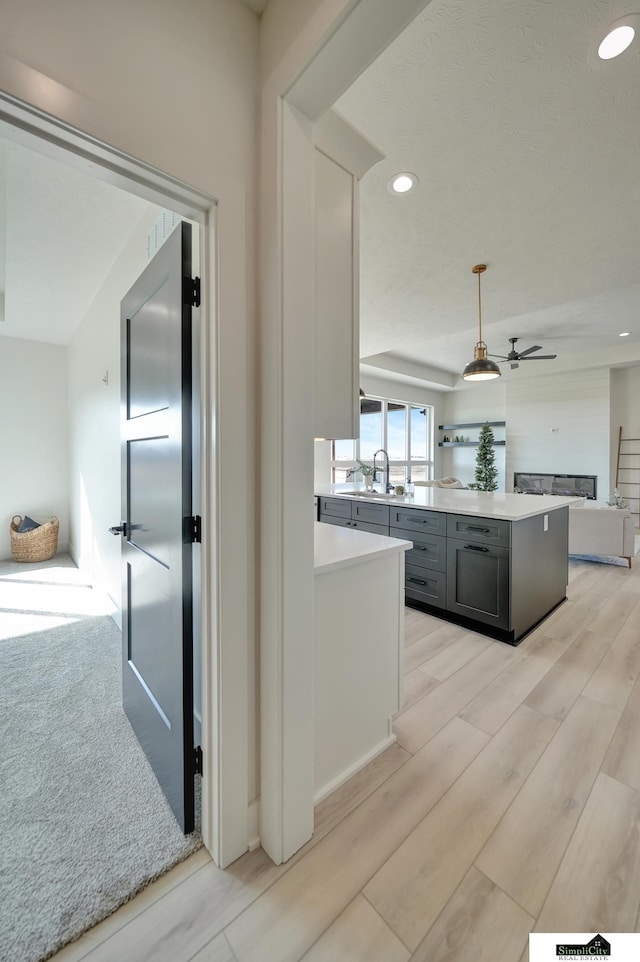 kitchen featuring recessed lighting, a sink, open floor plan, and light countertops