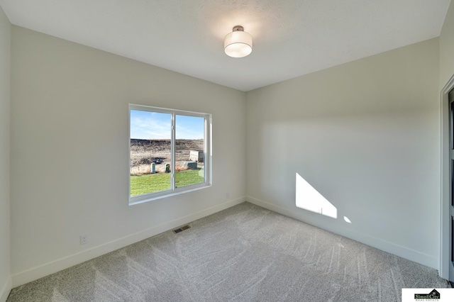 carpeted empty room with visible vents and baseboards