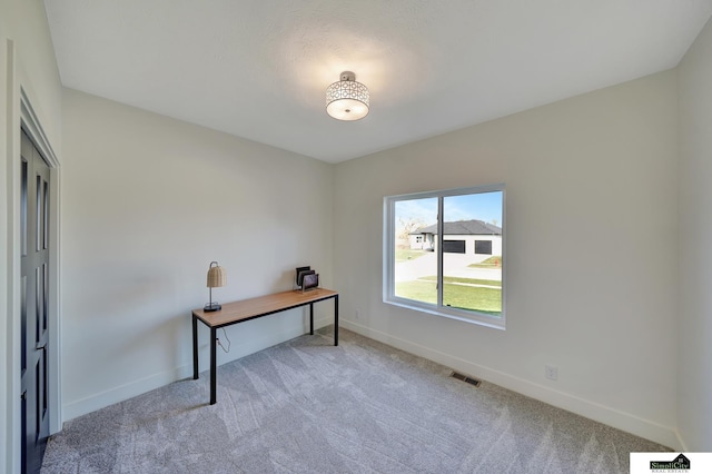 unfurnished office featuring visible vents, light colored carpet, and baseboards
