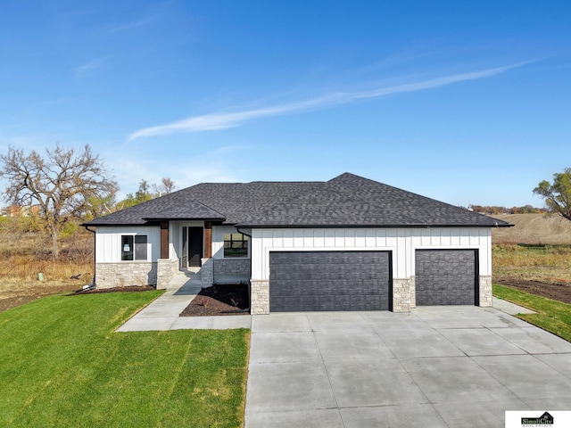 prairie-style house with stone siding, an attached garage, and roof with shingles