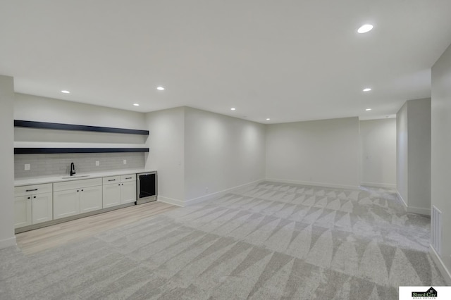 bar with recessed lighting, light colored carpet, backsplash, a sink, and wet bar