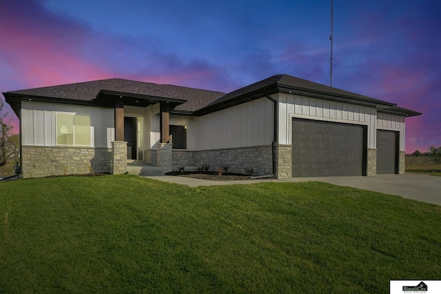 prairie-style house with concrete driveway, stone siding, an attached garage, and board and batten siding