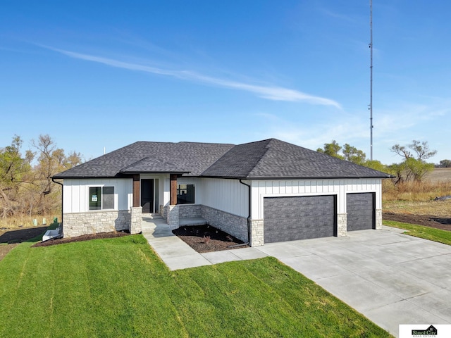 view of front of house with roof with shingles, an attached garage, and stone siding