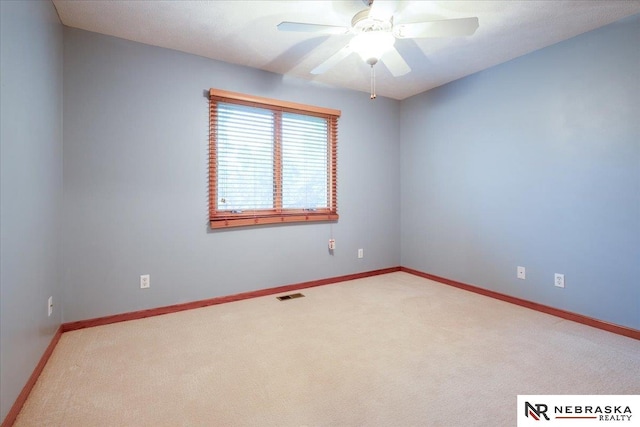 carpeted empty room with a ceiling fan and baseboards