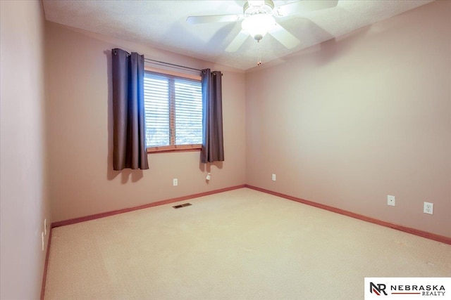 empty room with carpet flooring, ceiling fan, and baseboards