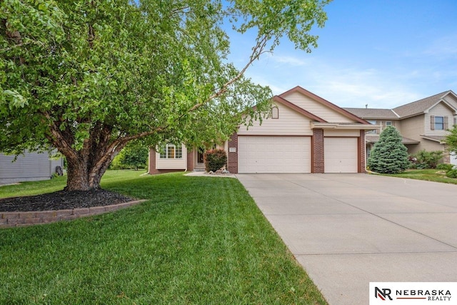 view of front of home with an attached garage, concrete driveway, brick siding, and a front lawn