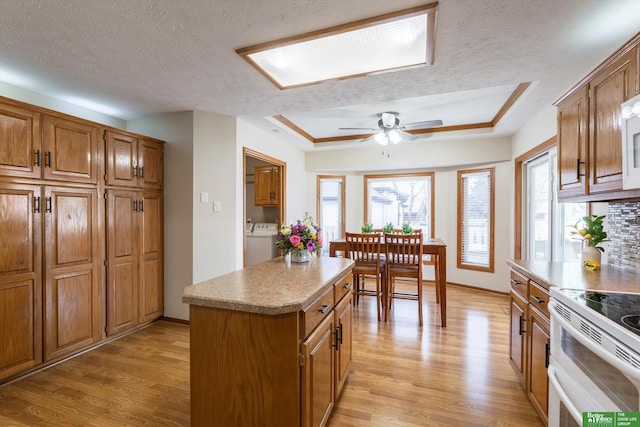 kitchen featuring double oven range, a textured ceiling, brown cabinets, and light wood finished floors