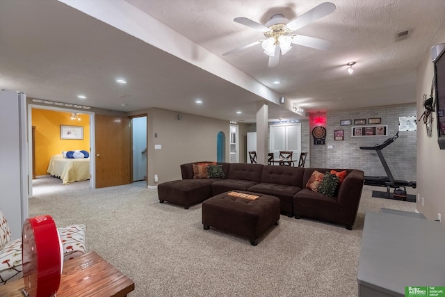 carpeted living area featuring recessed lighting, visible vents, ceiling fan, and brick wall