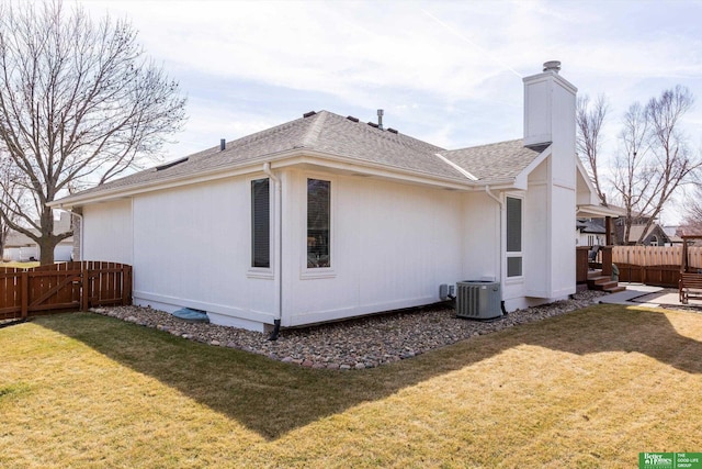 view of side of home featuring a lawn, a chimney, a gate, and fence