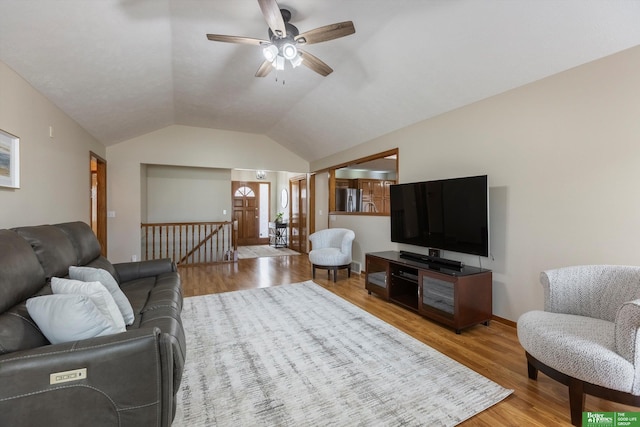 living area with a ceiling fan, light wood-style floors, and vaulted ceiling