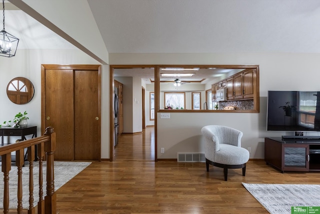entrance foyer featuring visible vents, wood finished floors, and ceiling fan with notable chandelier