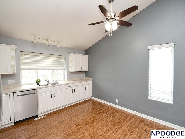 kitchen featuring lofted ceiling, a sink, dishwasher, and open shelves