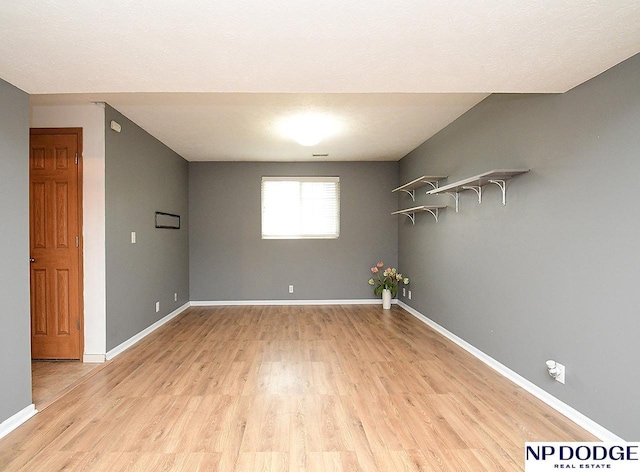 empty room with baseboards and light wood-style flooring