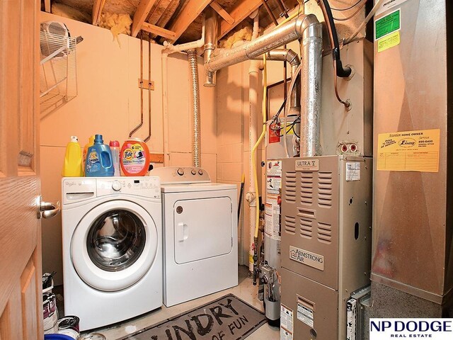 washroom featuring washer and clothes dryer, heating unit, and laundry area