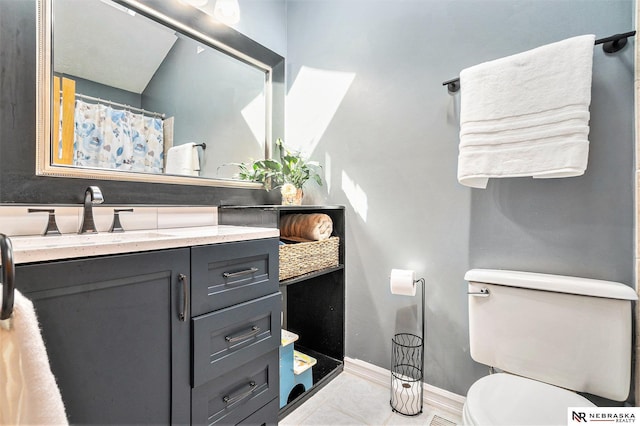 bathroom with baseboards, toilet, and vanity