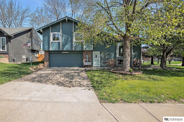 tri-level home with an attached garage, a front lawn, brick siding, stucco siding, and concrete driveway