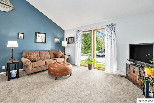 carpeted living area with baseboards and high vaulted ceiling