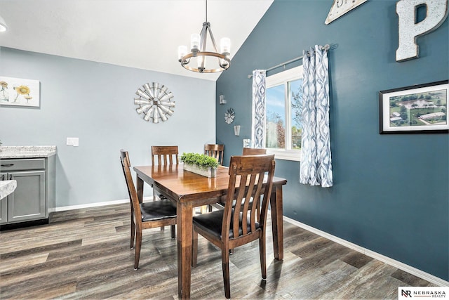 dining area featuring an inviting chandelier, baseboards, dark wood finished floors, and lofted ceiling