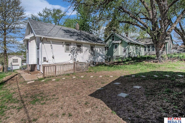 exterior space featuring a fenced backyard, a front lawn, a chimney, and a deck