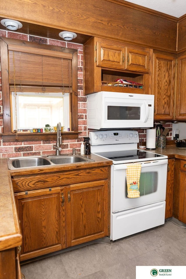 650 E 9th St, York, NE 68467 - kitchen with brown cabinetry, white appliances, and a sink