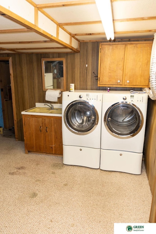 650 E 9th St, York, NE 68467 - laundry room featuring carpet floors, washer and dryer, cabinet space, wood walls, and a sink