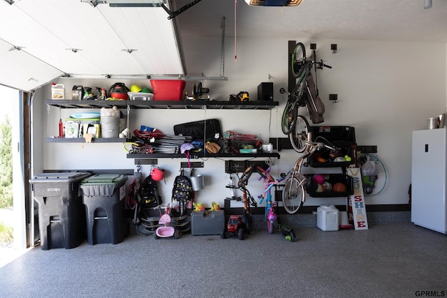 garage with freestanding refrigerator and a garage door opener
