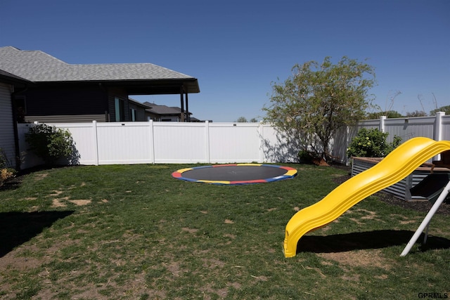 view of yard with a playground, a trampoline, and a fenced backyard