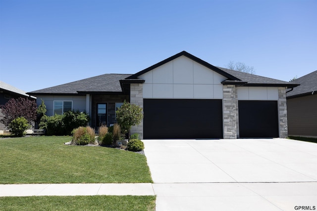 view of front of house with roof with shingles, an attached garage, stone siding, driveway, and a front yard