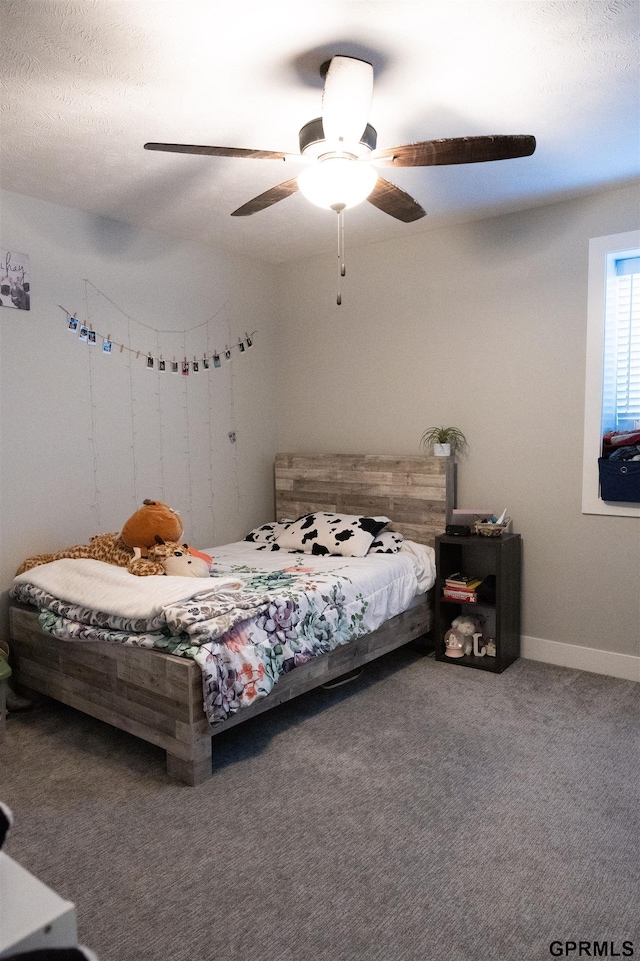 carpeted bedroom featuring baseboards and ceiling fan
