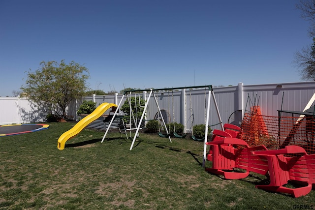 community playground with a fenced backyard and a lawn