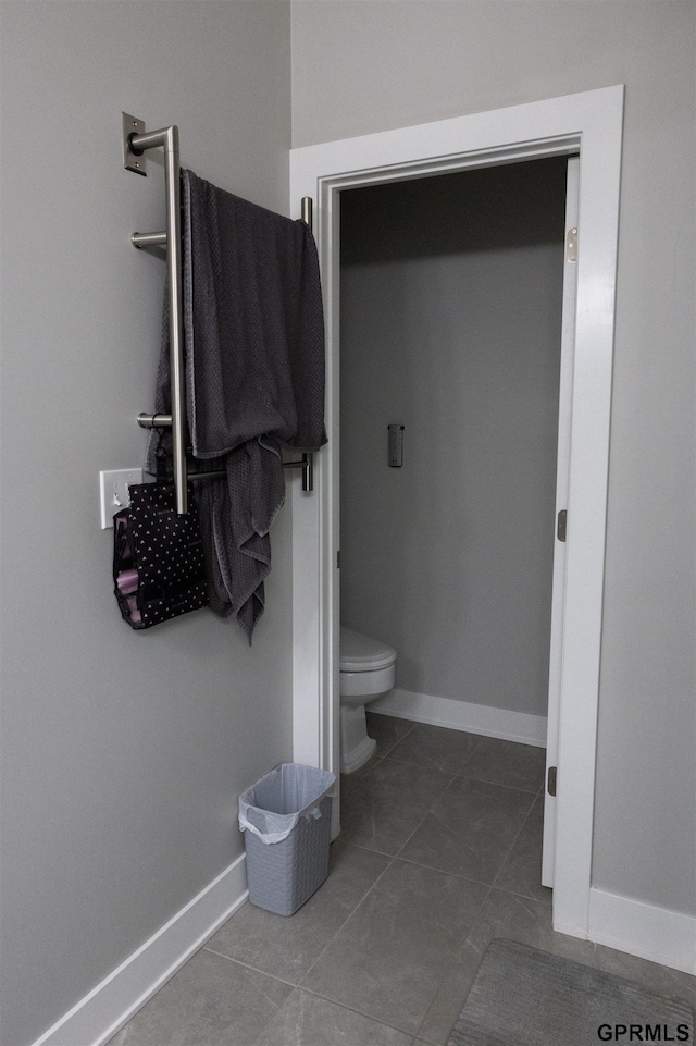 bathroom with toilet, tile patterned flooring, and baseboards