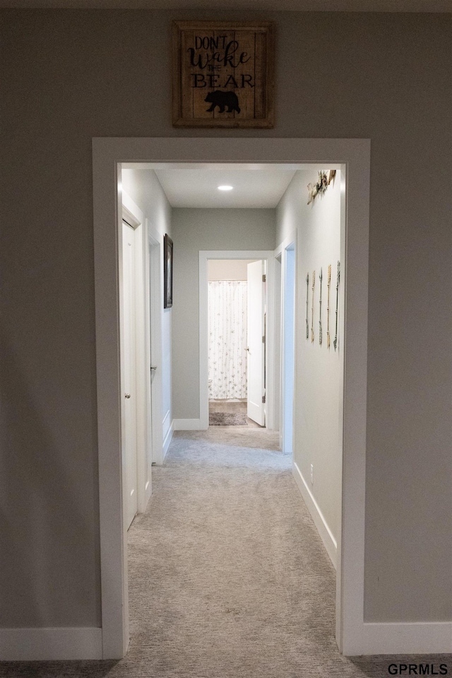 hallway with baseboards and carpet