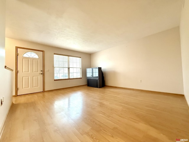entryway with baseboards and light wood-style floors