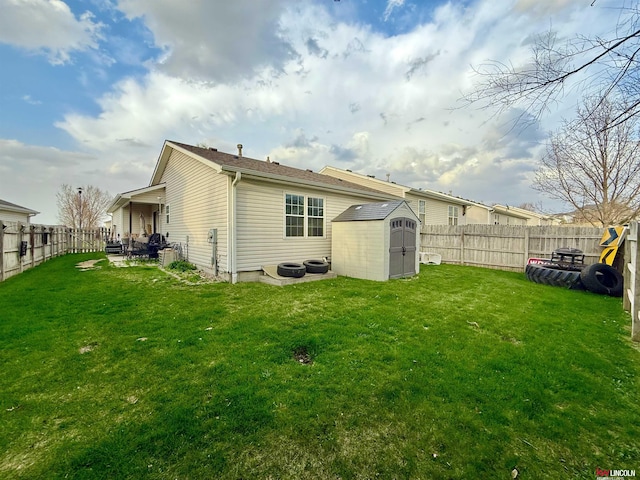 back of property with an outdoor structure, a storage shed, a lawn, and a fenced backyard