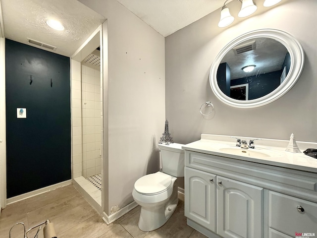 full bath featuring tiled shower, toilet, vanity, baseboards, and visible vents
