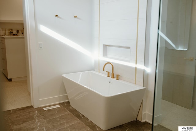 full bathroom with baseboards and a freestanding bath