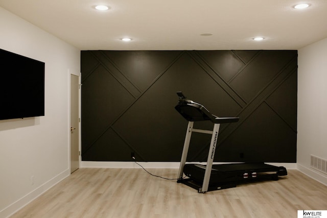 workout room featuring visible vents, recessed lighting, a decorative wall, and wood finished floors