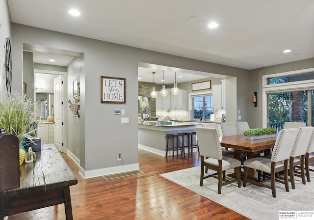 dining space featuring recessed lighting, light wood-style flooring, and baseboards