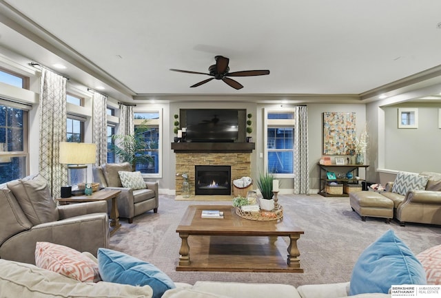 carpeted living room featuring crown molding, a fireplace, and a ceiling fan